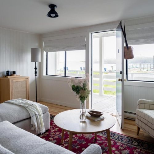 The seating area and view of the ocean in a room at Bluebird Ocean Point Hotel in East Boothbay, Maine.