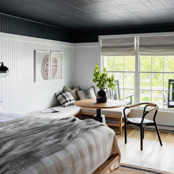 A simple and modern room with a queen bed and seating area at the Bluebird Ocean Point Inn hotel in East Boothbay, Maine.