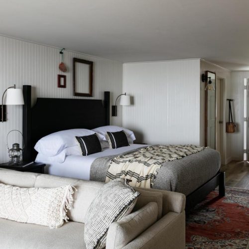 A view of an room with a double bed and cozy seating area at the Bluebird Ocean Point Hotel in East Boothbay, Maine