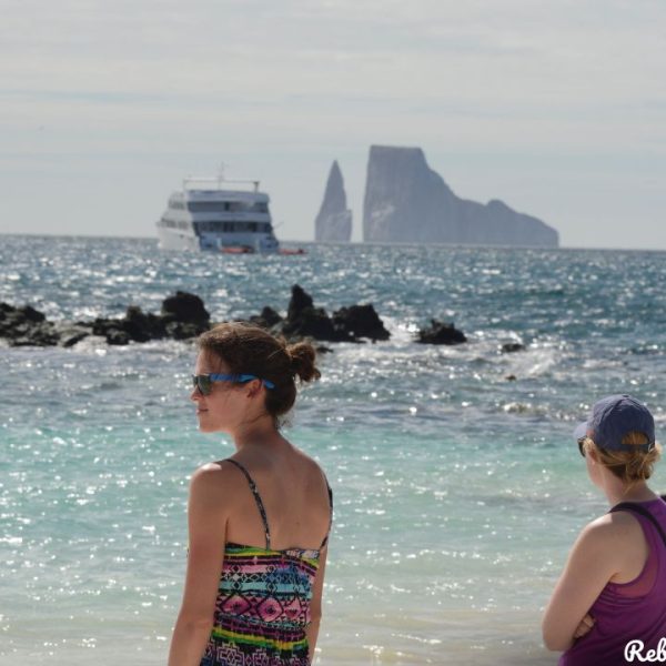 Two women gaze out at the breathtaking Galapagos beach, immersed in its natural beauty and tranquility - 8-Day Galapagos Women's Tour - Rebecca Adventure Travel