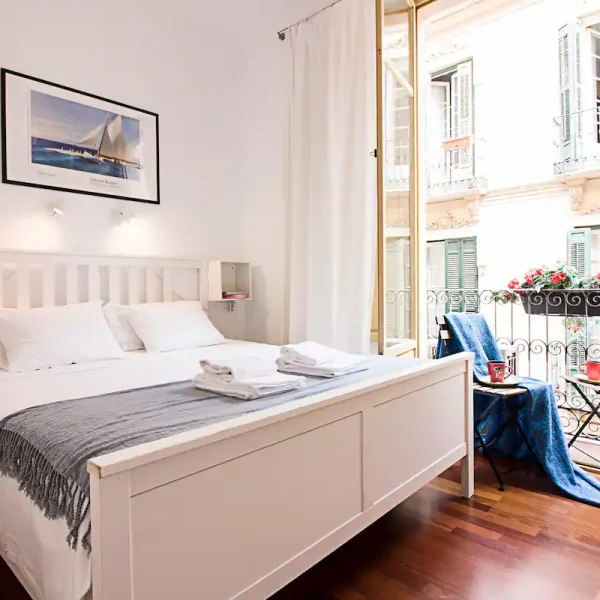 A queen room with a balcony viewing the street at FreshApartments by Bossh in Malaga, Spain, recommended by JourneyWoman readers as a safe place for women to stay.