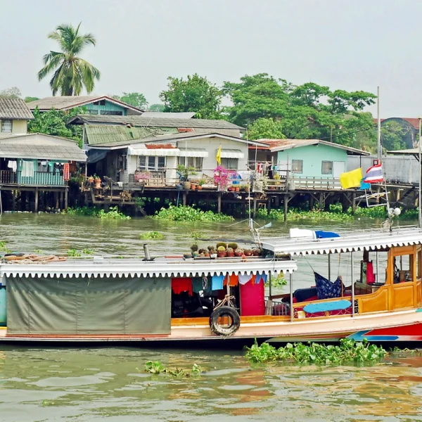 A low boat travels along the Khlong Noi Canal in Bangkok Thailand - Ancient Kingdoms: Thailand, Laos, Cambodia & Vietnam Overseas Adventure Travel