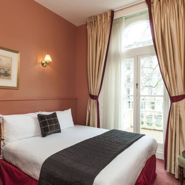 A simply decorated single room with double bed at the Victorian Rose Park Hotel in London, England, recommended as a safe place for women to stay by JourneyWoman readers.