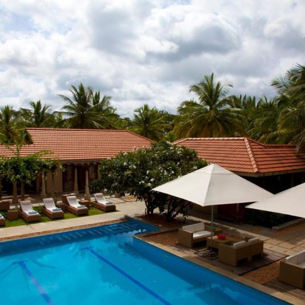 A peaceful poolside scene at the Shreyas Yoga Retreat in Bangalore, India, recommended as a safe place for women to stay.