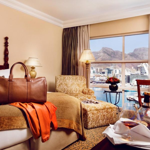 A beautiful room with a double bed and a view of the waterfrton at the Table Bay Hotel in Cape Town, South Africa, recommended as a safe place for women to stay by a JourneyWoman reader.