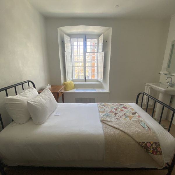 As imple room with a double bed and view of the courtyard at Les Monastere des Augustines, Quebec City, Quebec, Canada, recommended by JourneyWoman as a safe place for women to stay.