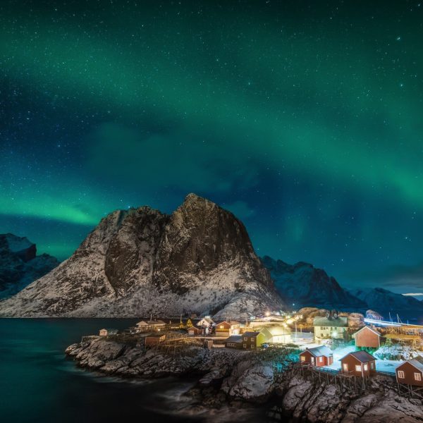 The Northern Lights shine over the village of Lofoten Hamnoy - Hurtigruten Norway - Follow the Northern Lights North