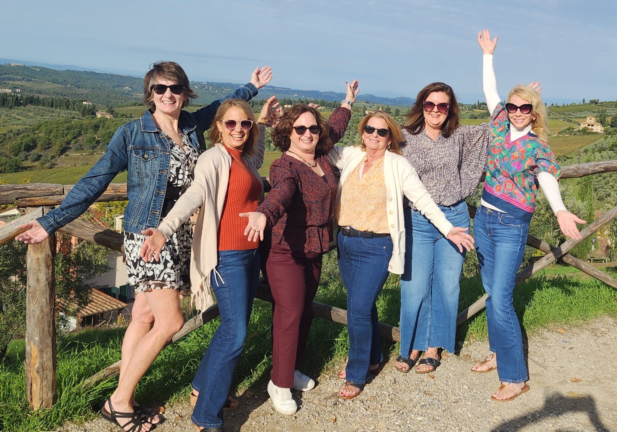 A joyful group of women bonding and relaxing during the Women's Wanderlust Retreat in the picturesque hills of Tuscany.