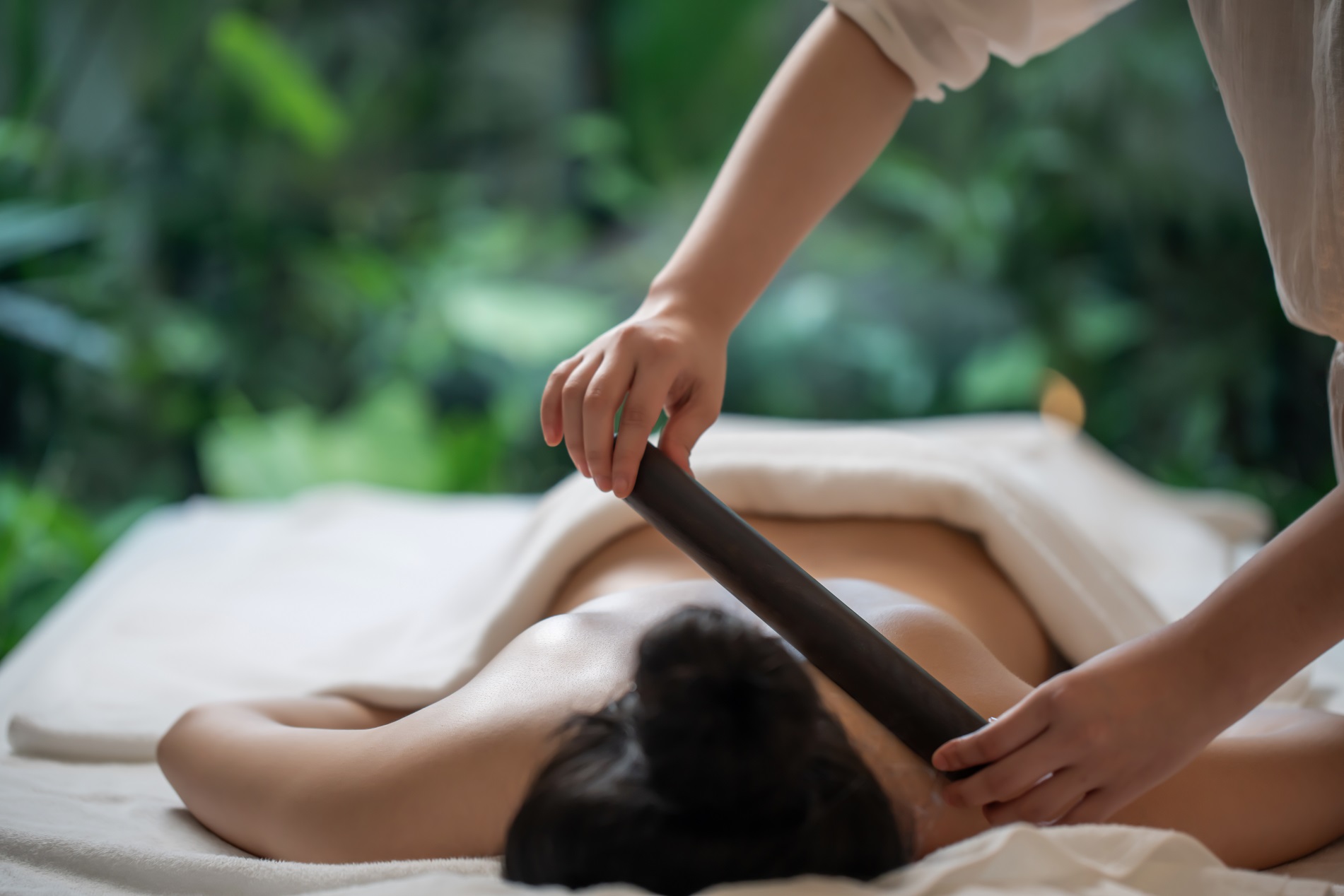 Relaxed woman receiving a massage at a luxurious resort spa, surrounded by a serene ambiance.