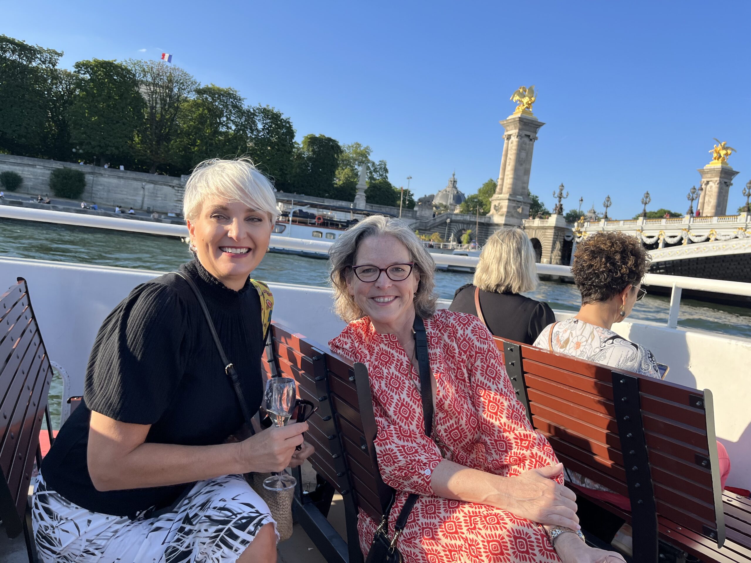 Two women enjoying the sunset cruise on Seine - Insider Tour of Paris Neighborhoods