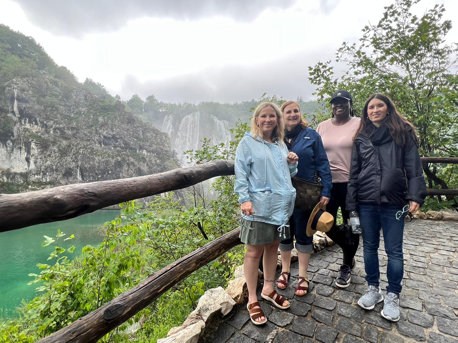 A group of women exploring Plitvice Lakes National Park, surrounded by lush greenery and cascading waterfalls.