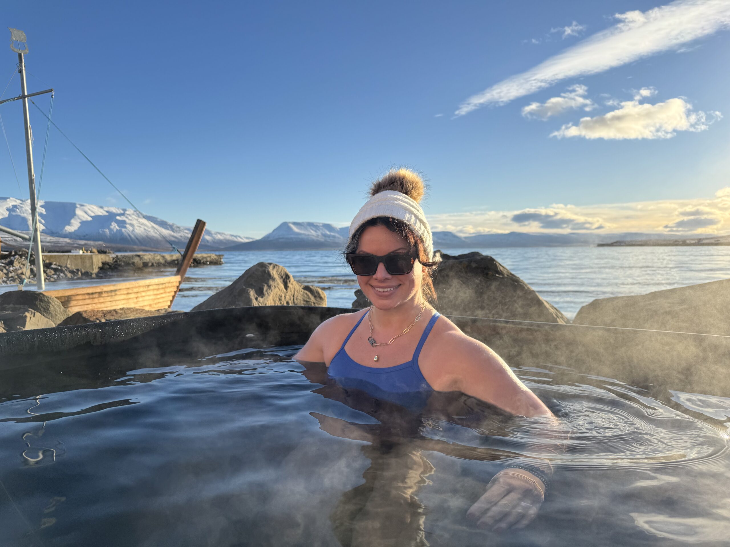 A woman in shades enjoys a hot springs soak, part of the Women’s Wellness Retreat In Iceland Hot Springs & Mindfulness by Green Edventures