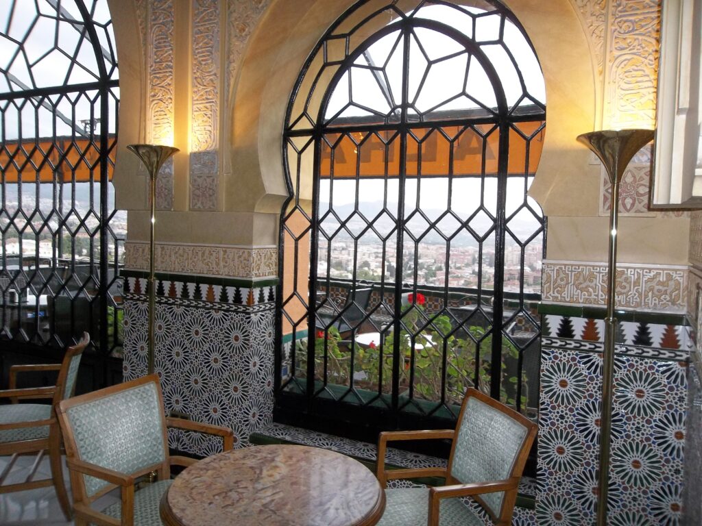 Extravagant windows in the seating area of the Alhambra Palace Hotel in Granada Spain, recommended by a JourneyWoman reader as a safe place for women to stay.