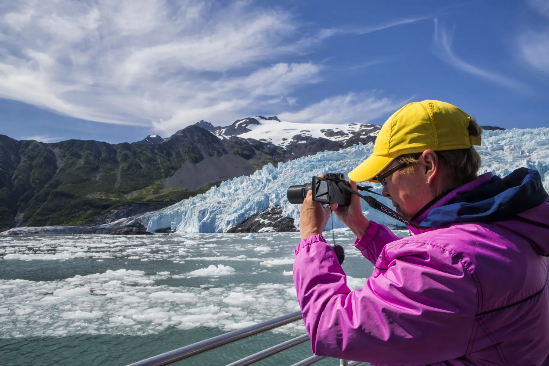 Woman capturing a photo of majestic Alaskan glaciers